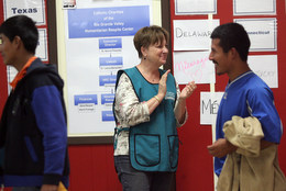 Deb Boyce of Catholic Charities greets guests to the Humanitarian Respite Center
