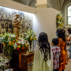 family praying by St. Anthony statue