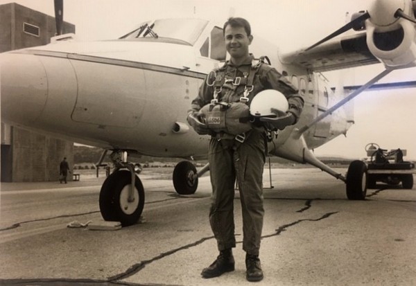 Fr Bob standing by airplane