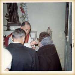 Two people receive Eucharist in chapel