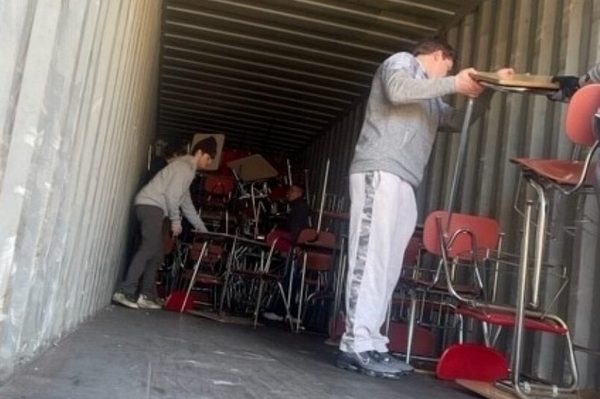 students stacking chairs in truck