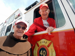 Friar with man in fire truck