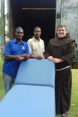 Friar and 2 men carry hospital bed