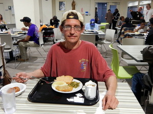 Guest with dinner tray in dining room.