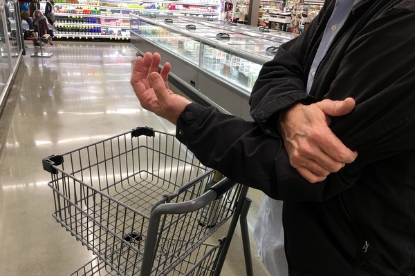 man holding arm in store