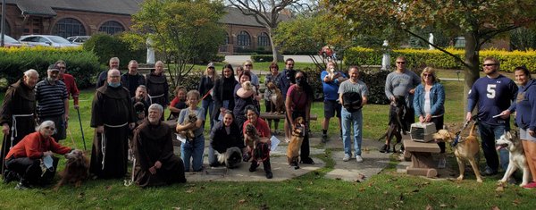 friars and parishioners outside with pets