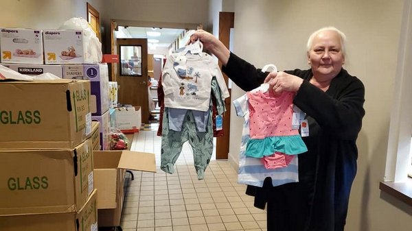 woman holding baby outfits