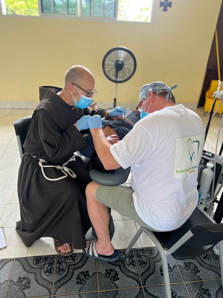 Br. John assists with dental work