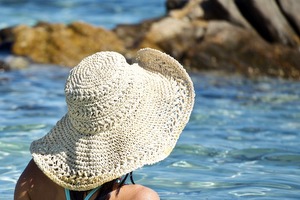 woman in sun hat by water