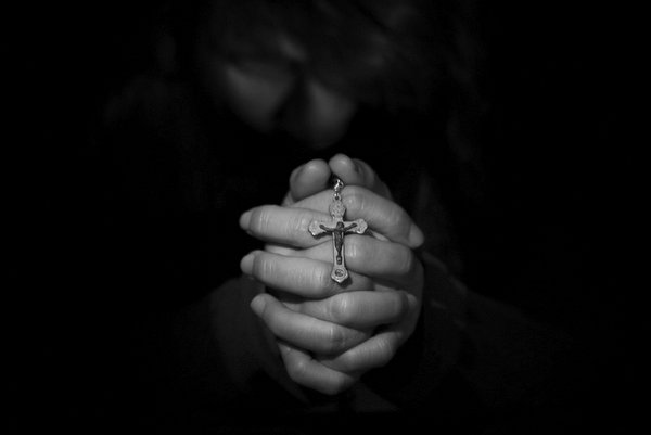 Hand praying with rosary